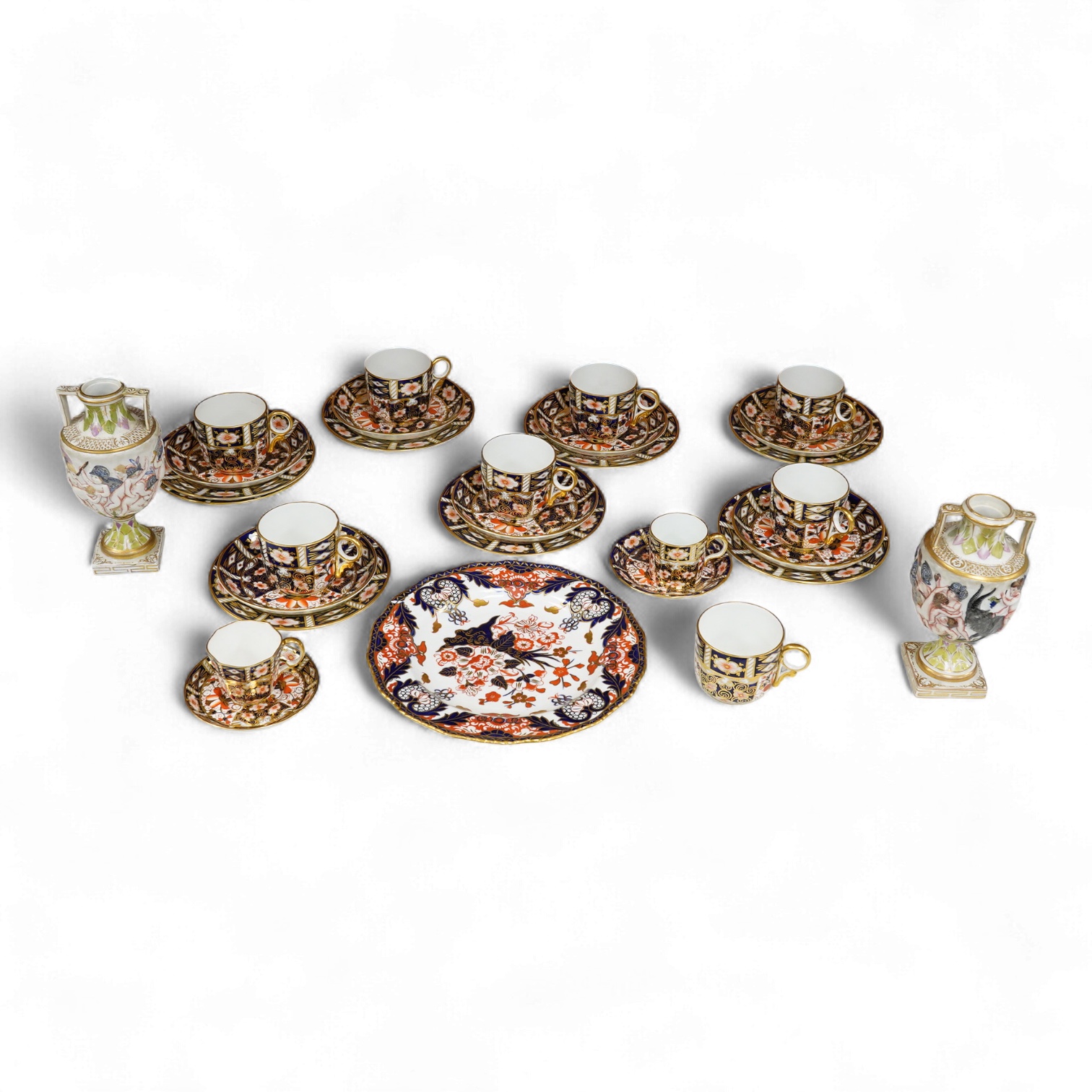 A Crown Derby Imari seven trio place setting, three other cups and two saucers, a large plate and a pair of Doccia- style vases, 18cm high